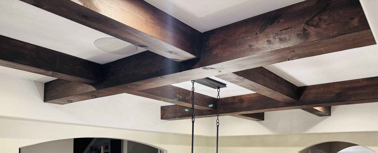 Stained timber beams forming a finished coffered ceiling
