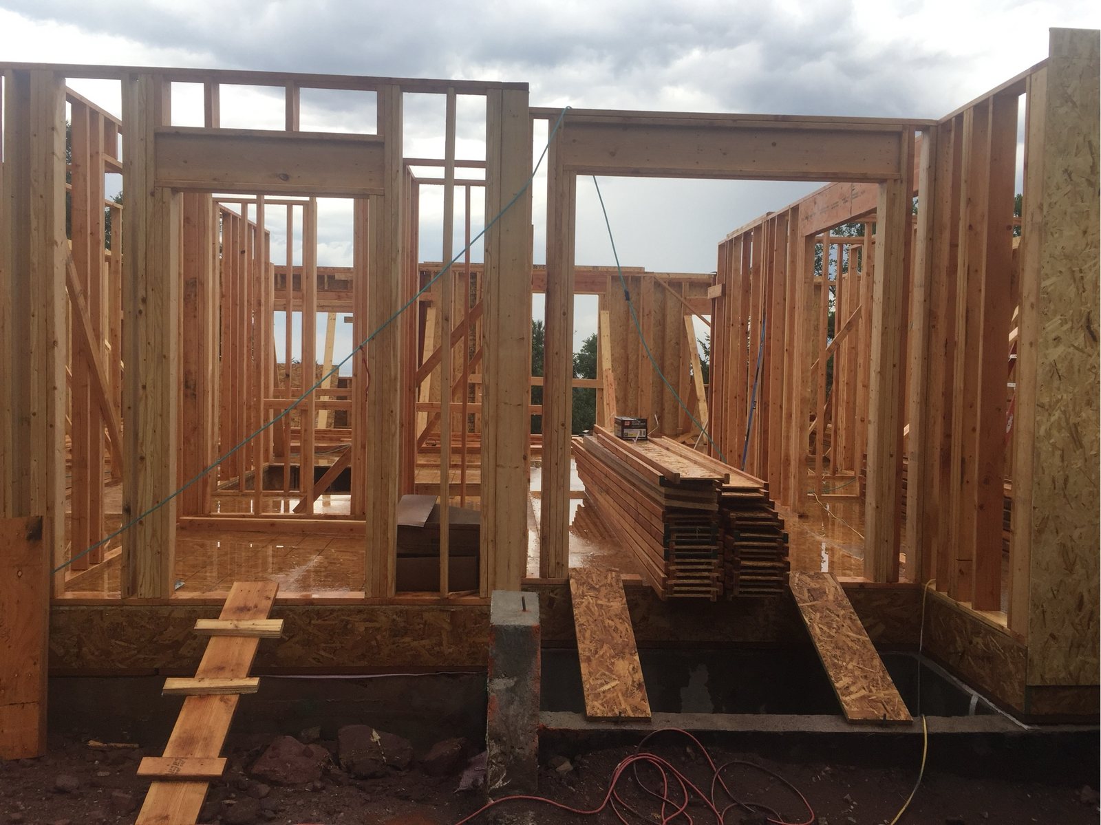 Interior framing complete with stacked lumber on the deck