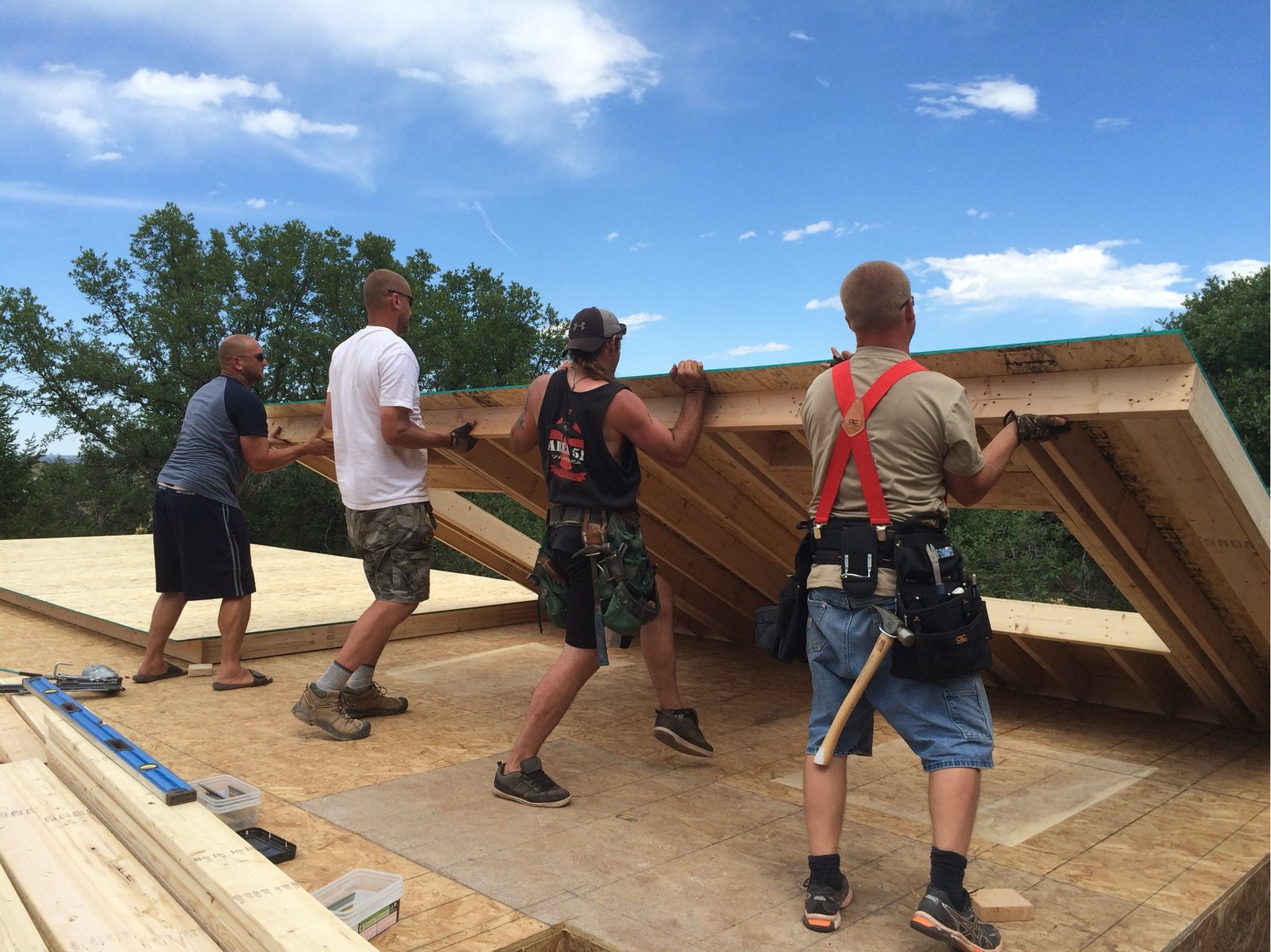 The framed wall part-way up as the crew walks it upright