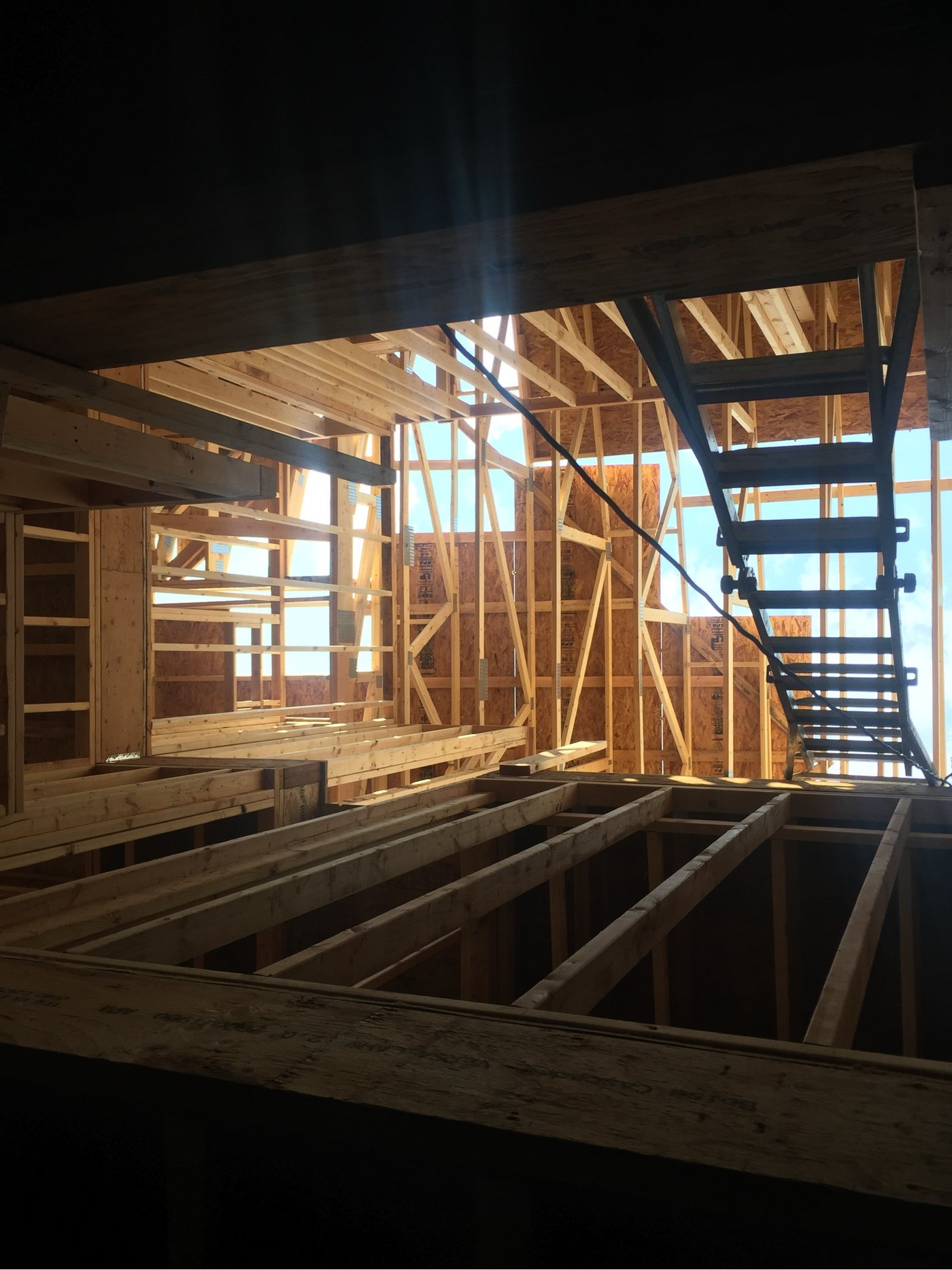 Framed stair opening with daylight falling down through the structure