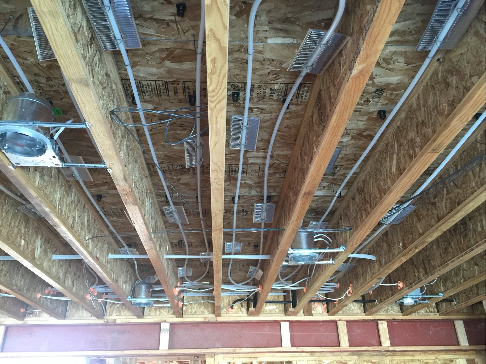 View up into an open floor system showing coordinated plumbing, wiring and ductwork