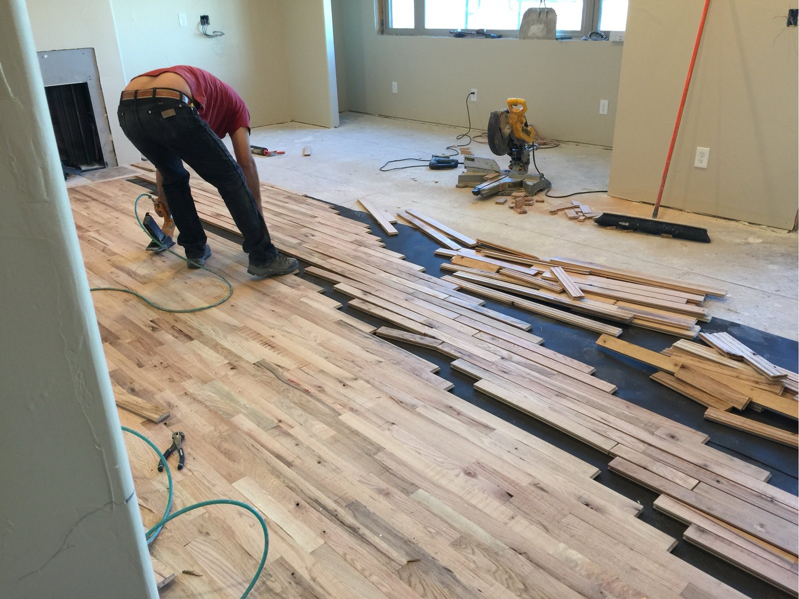 Hardwood plank flooring being laid, loose planks racked out ahead of the installer