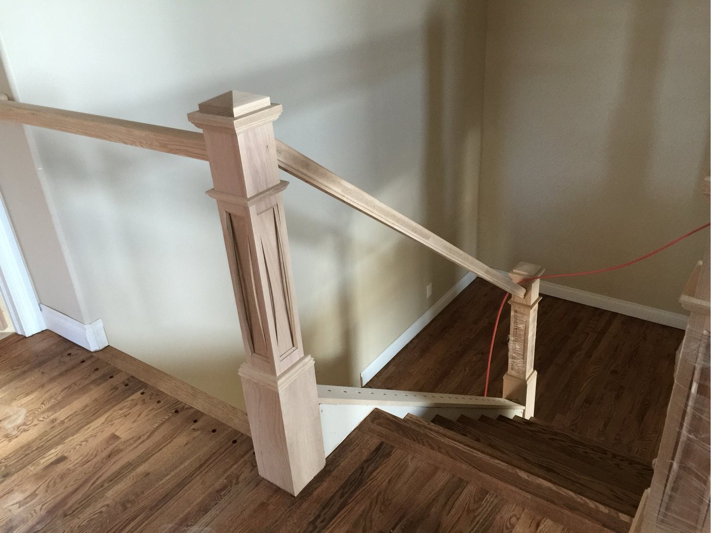 Stair handrail and newel post dry-fitted in unfinished wood